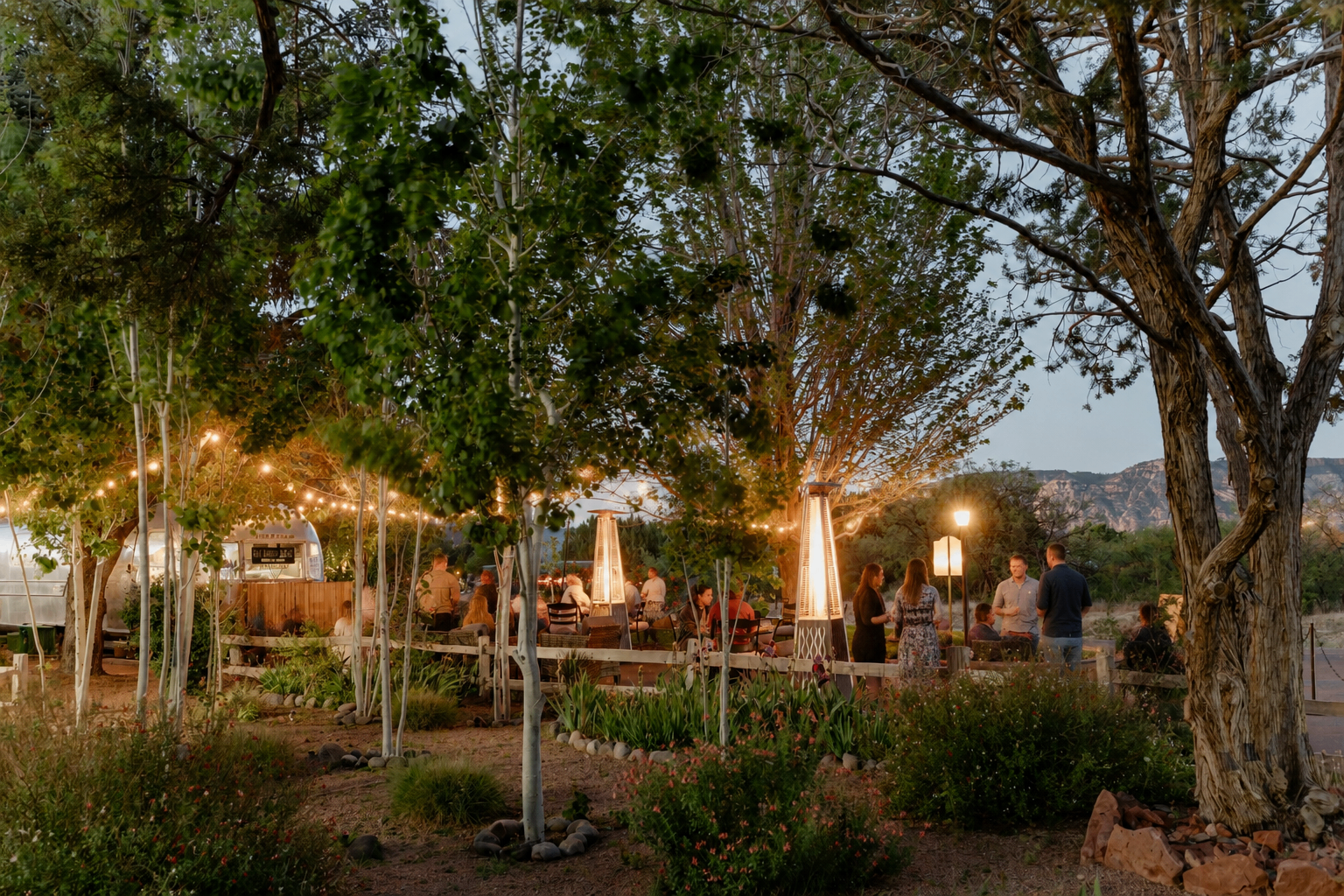 Outdoor reunion gathering at Sky Ranch Lodge with string lights, patio heaters, and red-rock views